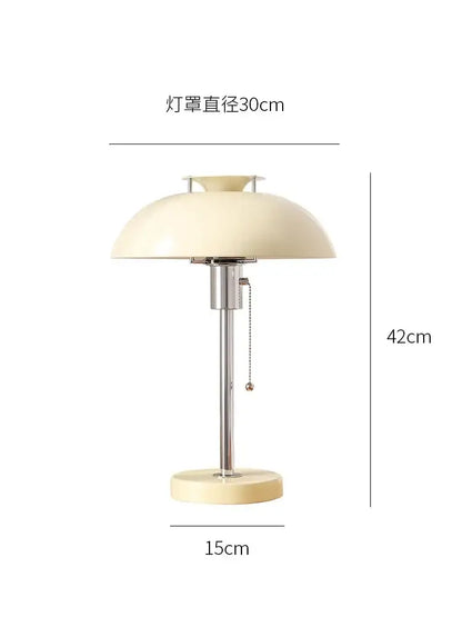 Cream-colored dome-shaped lampshade with chrome stem and base on bauhaus red glossy ceramic led table lamp for bedroom