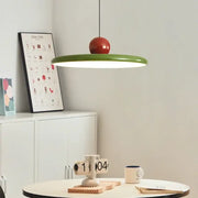 A modern bauhaus saucer chandelier with a vibrant green circular shade and glossy red spherical top for dining rooms