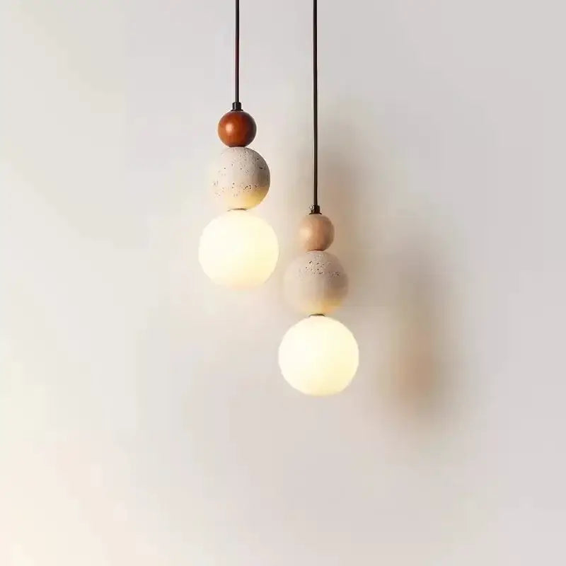 Two pendant lights feature tiered travertine stone and natural wood with warm glass globes that works beautifully in dining rooms