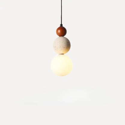 A modern pendant light with stacked spheres in warm wood, travertine stone, and frosted glass works beautifully