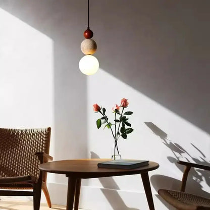 A modern pendant light with red and beige travertine stone shades and white glass works beautifully in dining rooms