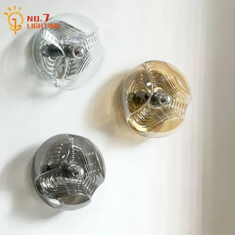 Three spherical bauhaus wavy glass wall lamps with metallic interiors and polished chrome centers for bedroom lighting