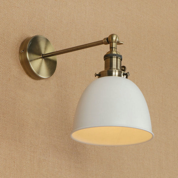 White dome-shaped bedroom wall sconce with brass accents and adjustable arm for versatile lighting