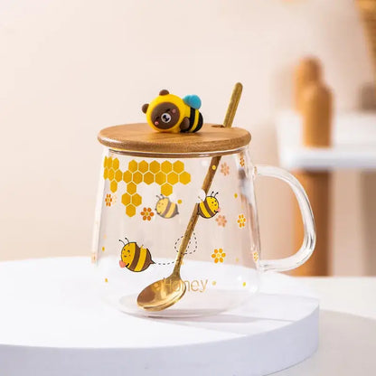 Bee glass spoon milk cup made of clear glass with yellow bee and hexagon patterns, bamboo lid, and gold spoon