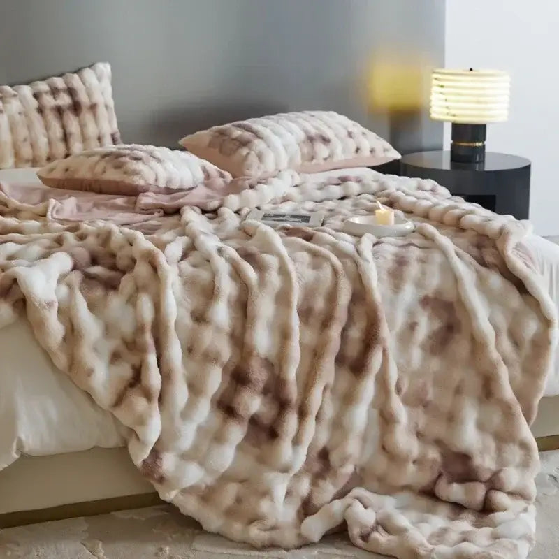 A beige and brown mottled faux fur decorbites cozy fleece throw blanket with a chunky textured weave for bedroom use