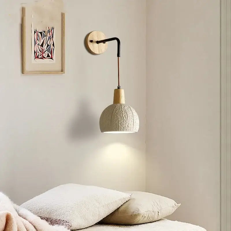 Beige cement shade wood wall sconce with textured off-white ceramic shade and black metal arm for bedroom decor