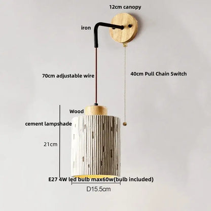Beige ceramic wall sconce with cylindrical cement lampshade and pull chain switch mounted on wooden canopy
