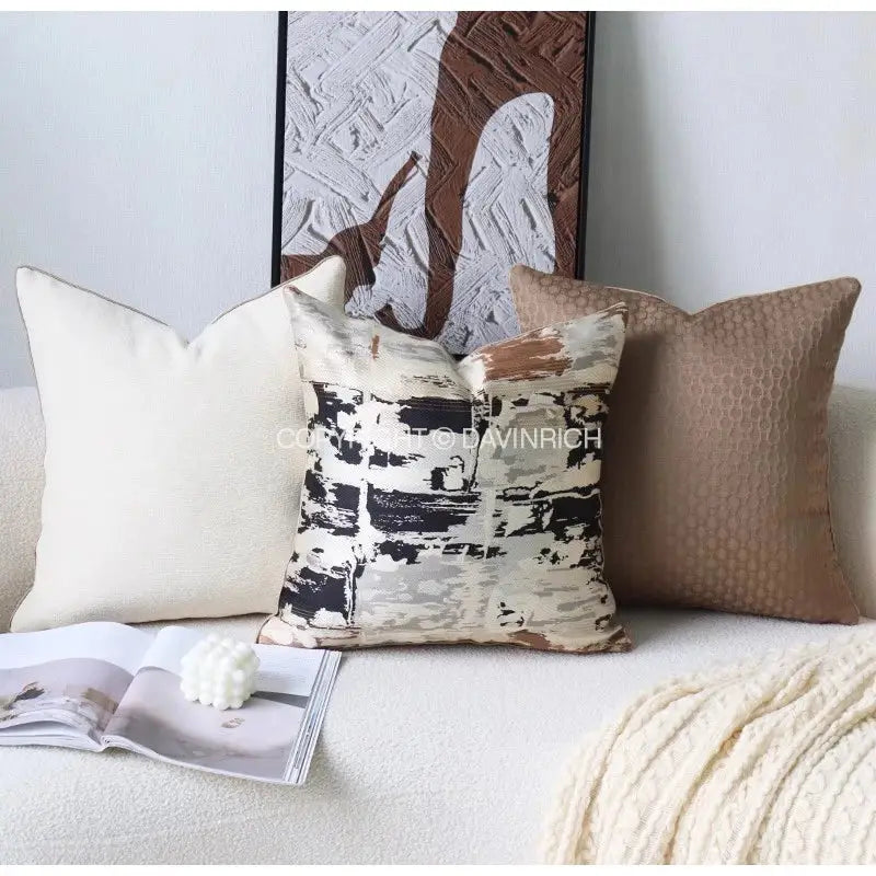 Cream-colored abstract throw pillow with black beige and brown brushstroke design in beige convex rings geometry jacquard cover