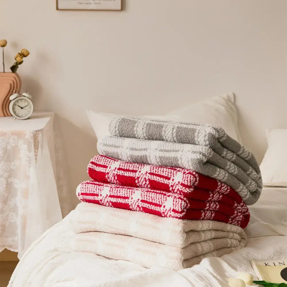 Stack of decorbites fluffy stripe microfiber throw blankets in red and gray stripe plaid patterns with white accents