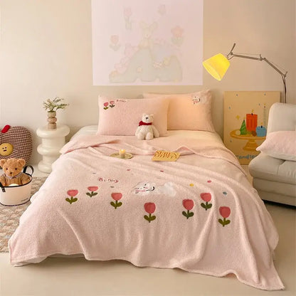 Beige embroidered teddy fleece blanket with pink plush cozy teddy fleece featuring red tulips and white bunny decorbites design