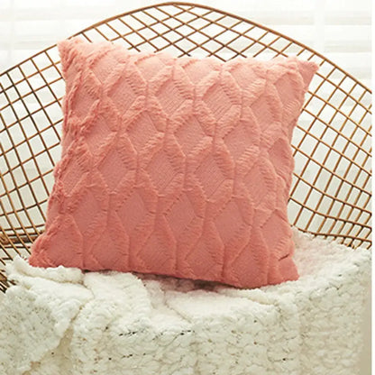 A soft blush pink cushion cover with a textured geometric diamond pattern for living room decor