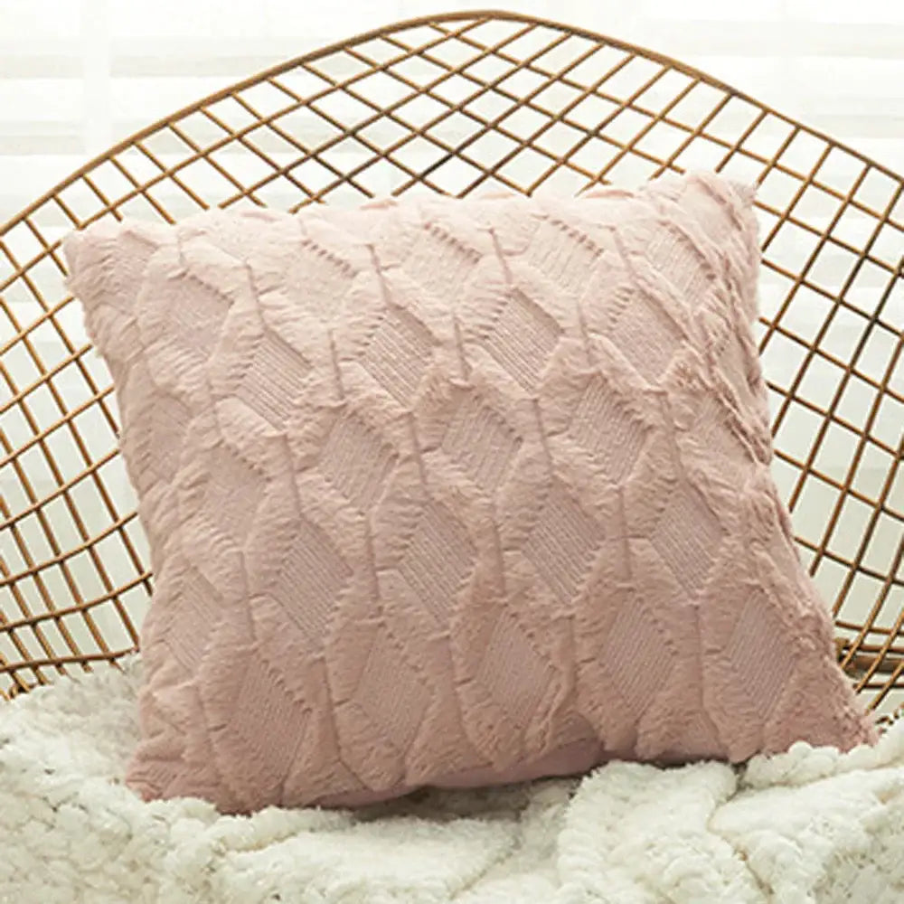 A soft blush pink textured throw pillow with a geometric diamond pattern knit cushion cover for living room use
