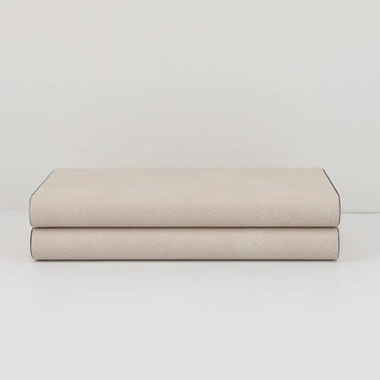 A beige leather jewelry box storage container with textured light beige leather and dark binding edges by decorbites