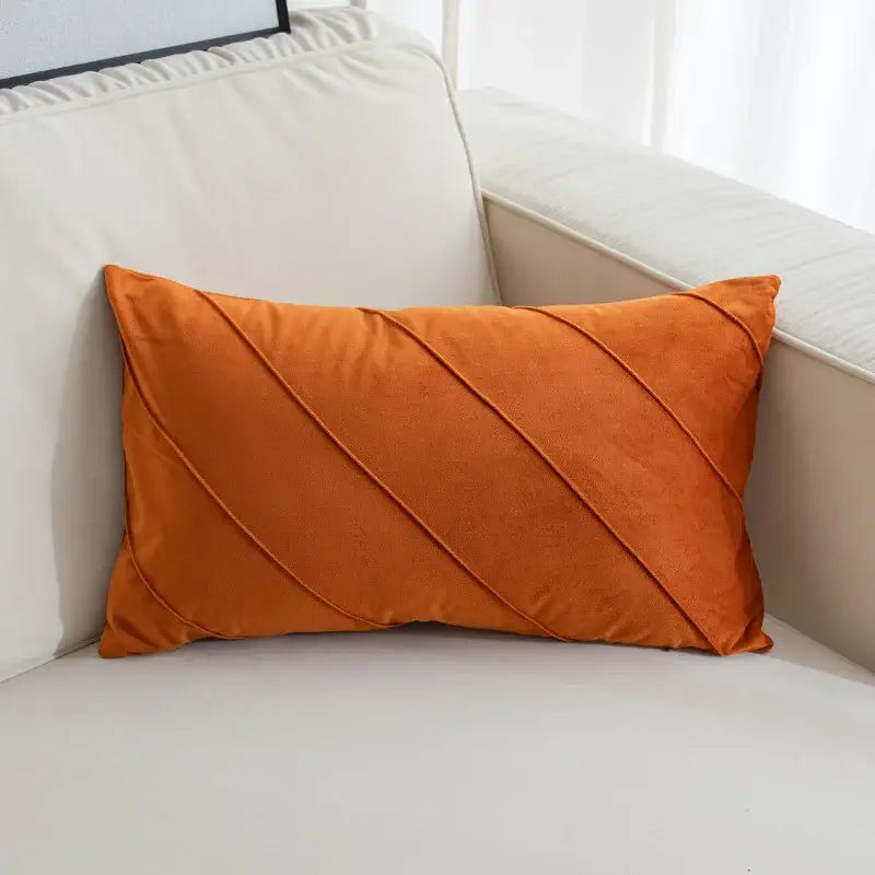 A rectangular orange velvet living room pillow with hand pleat embroidered diagonal pleats for decorative use