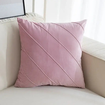 A soft pink velvet throw pillow with diagonal stitching featuring hand pleat embroidered design for living room use