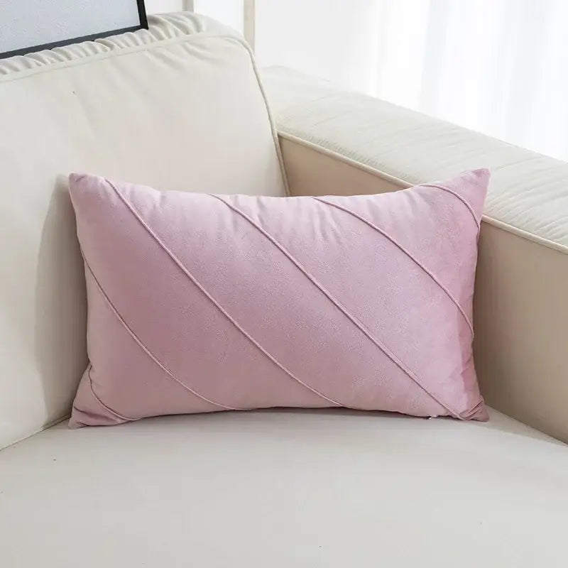A soft pink velvet rectangular pillow with diagonal stitching featuring hand pleat embroidered detailing for living room use