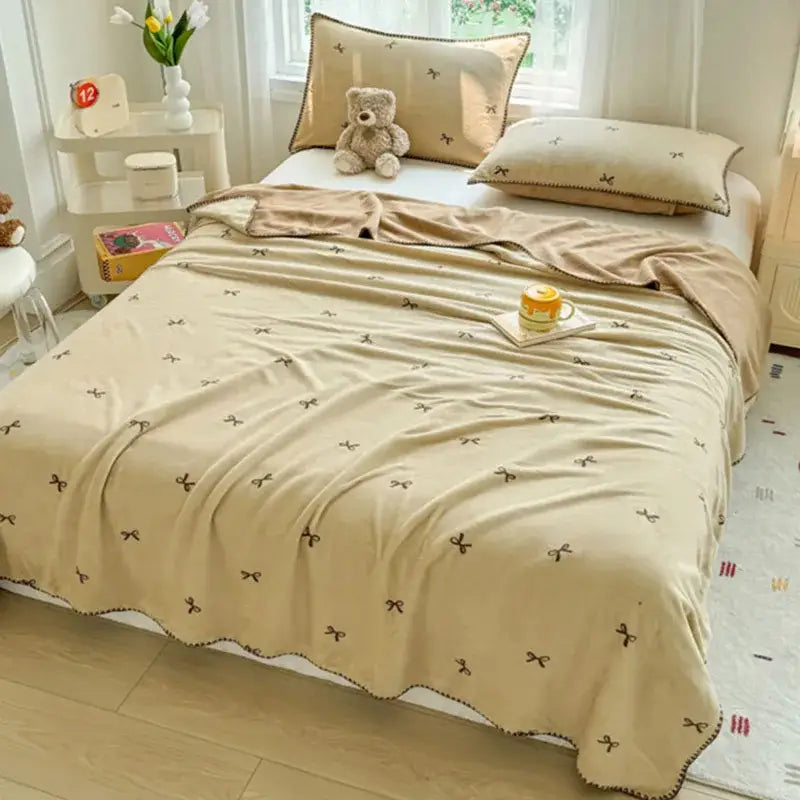 Beige scalloped cozy coral fleece blanket with small brown bow patterns ideal for bedroom decorbites cozy coral use