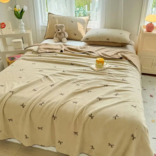 Beige scalloped cozy coral fleece blanket with small brown bow embroidery perfect for bedroom decorbites cozy coral use