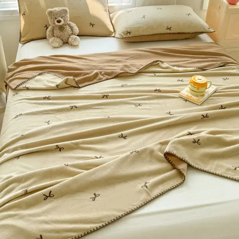 Beige scalloped cozy coral fleece blanket with small brown bow patterns and stitched border for bedroom decorbites cozy coral fleece