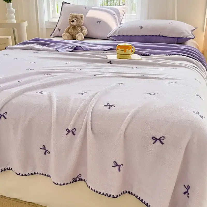 Soft lavender coral fleece blanket with scalloped edge and delicate purple bow embroidery for cozy coral fleece decorbites