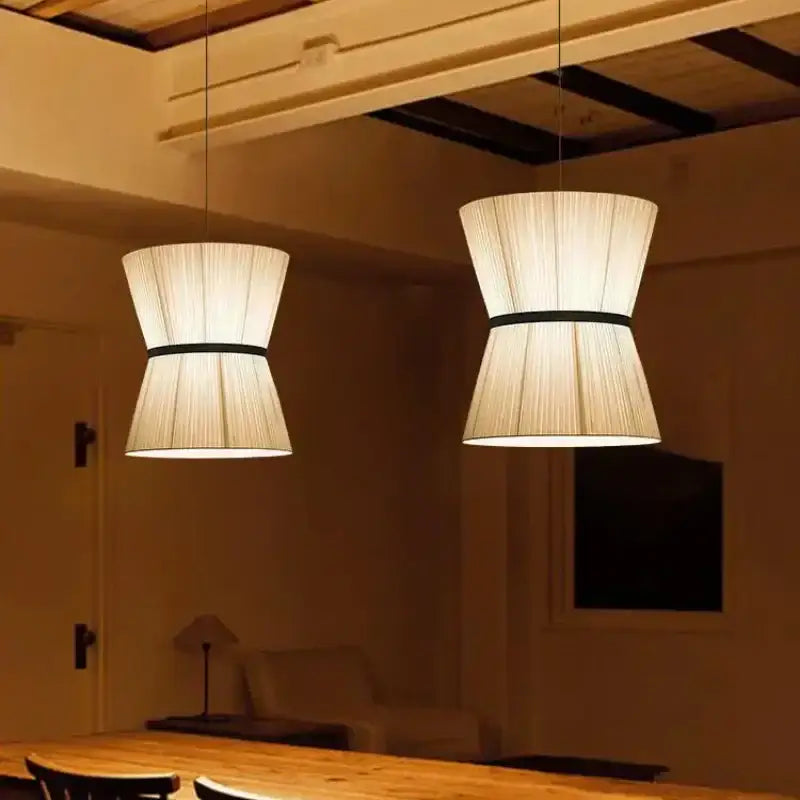 Two beige tapered pendant lamps with black bands in decorbites cocoon cloth chandelier for kitchen lighting