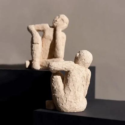 Beige textured abstract resin figurine sculpture of two seated human figures on dark pedestals for living room decorbites decor