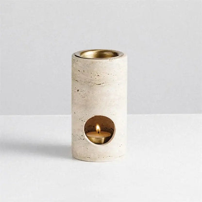 Beige travertine stone essential oil burner with cream-colored stone diffuser and brass interior housing lit tea light candle