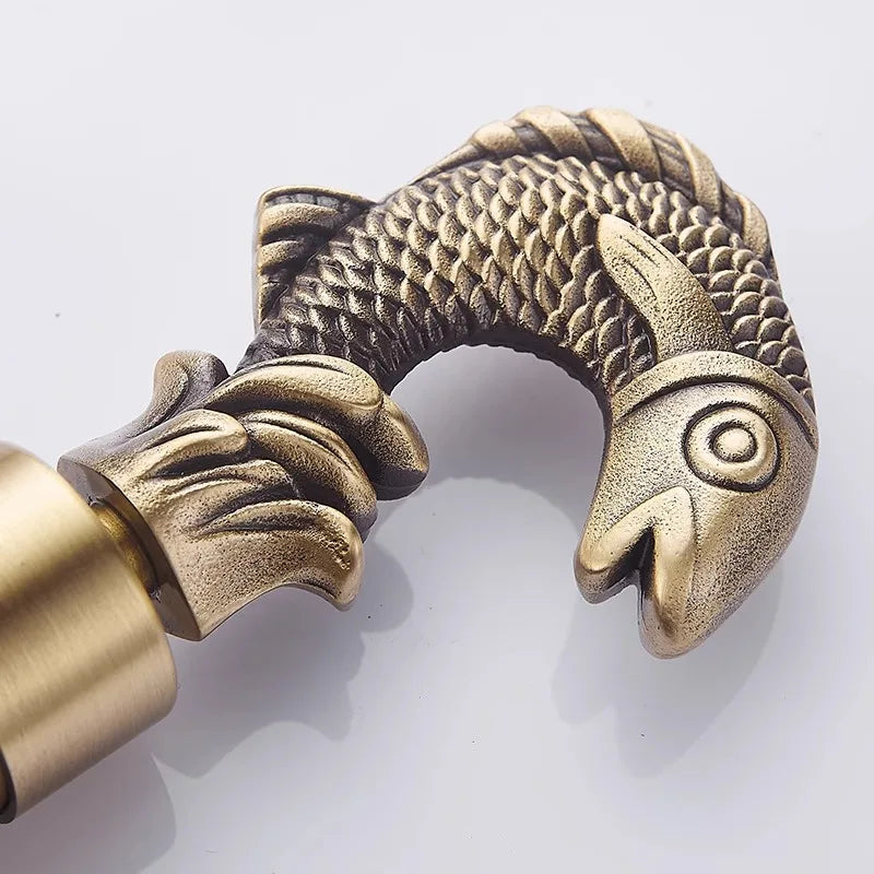 Antique brass fish-shaped curtain rod holder with detailed scales and ornate fins suitable for washing machine use