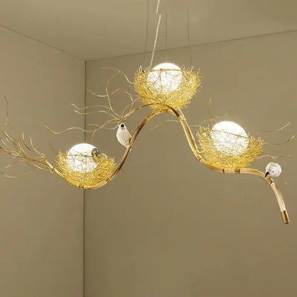 Golden bird nest led pendant light with intricate woven wire nests and white birds on curved bamboo branches for dining room and cafe decor