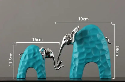 A pair of turquoise and silver decorbites elephant figurines with textured geometric surfaces as golden resin sculpture