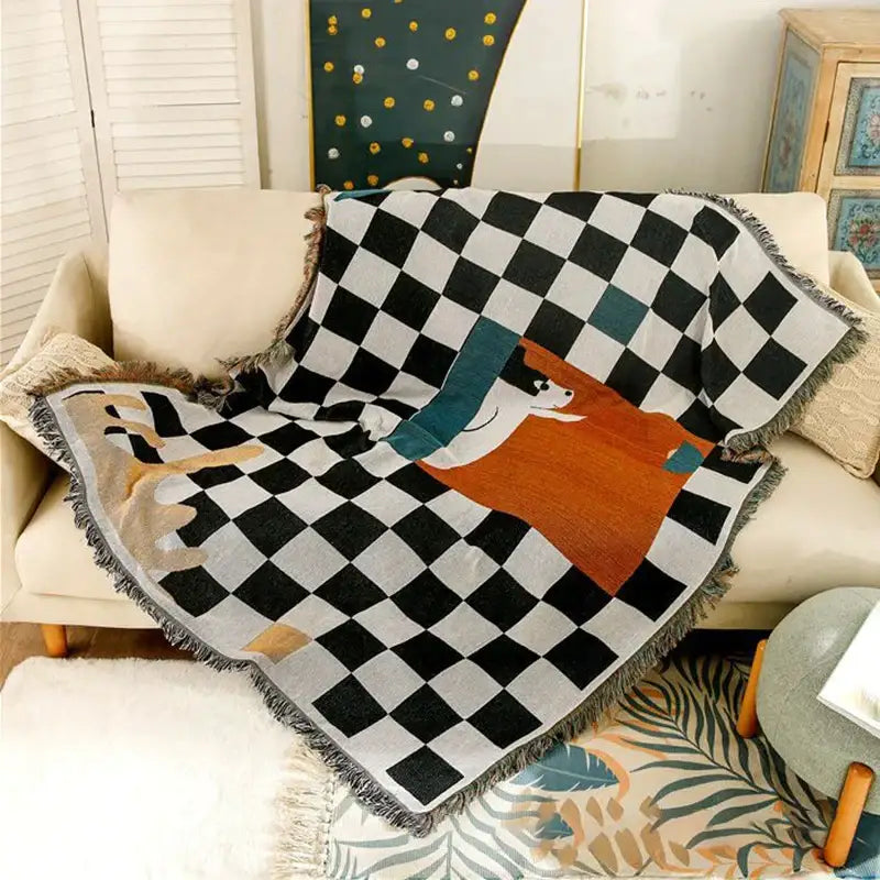 Black and white fox cozy plaid wool blend bedroom throw with cartoon dog design in orange teal beige tones and fringed edges</assistant
