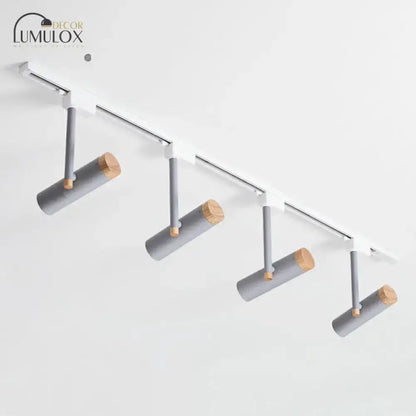 Modern DecorBites™ Nordic tubular metallic spotlight with four gray cylindrical fixtures and natural wood caps on white rail