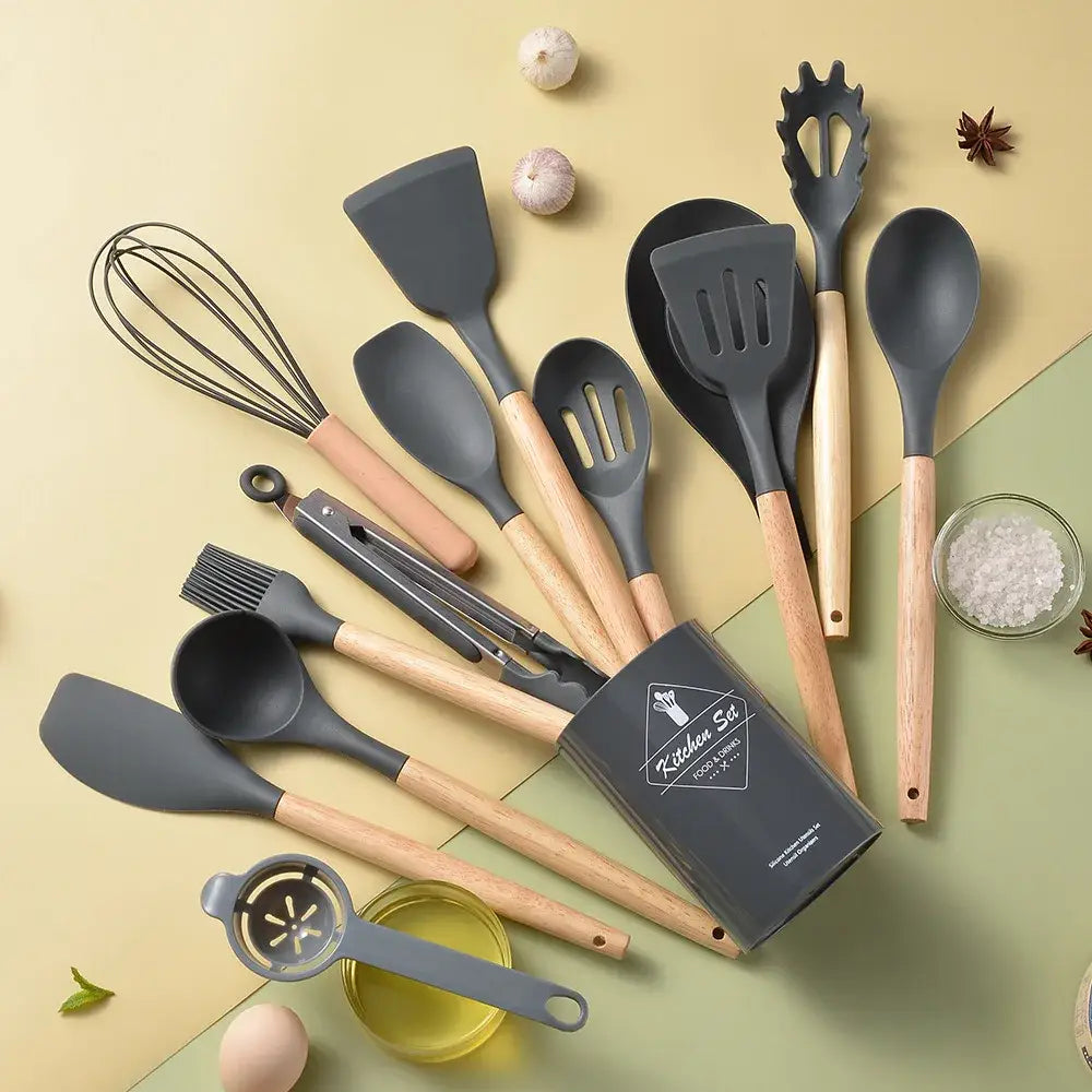 Set of gray silicone kitchen utensils with wooden handles in a black storage box kitchen utensil set
