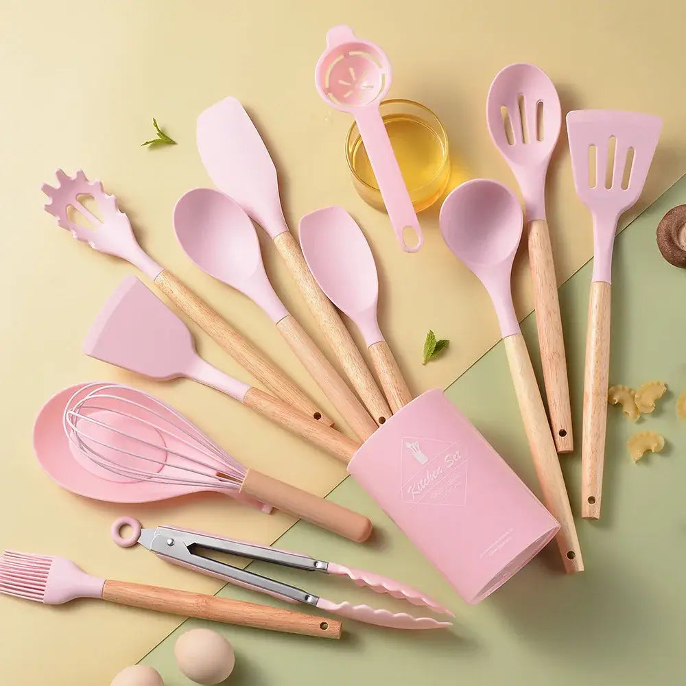 Pink silicone kitchen utensil set with wooden handles and matching pink storage cup for kitchen organization