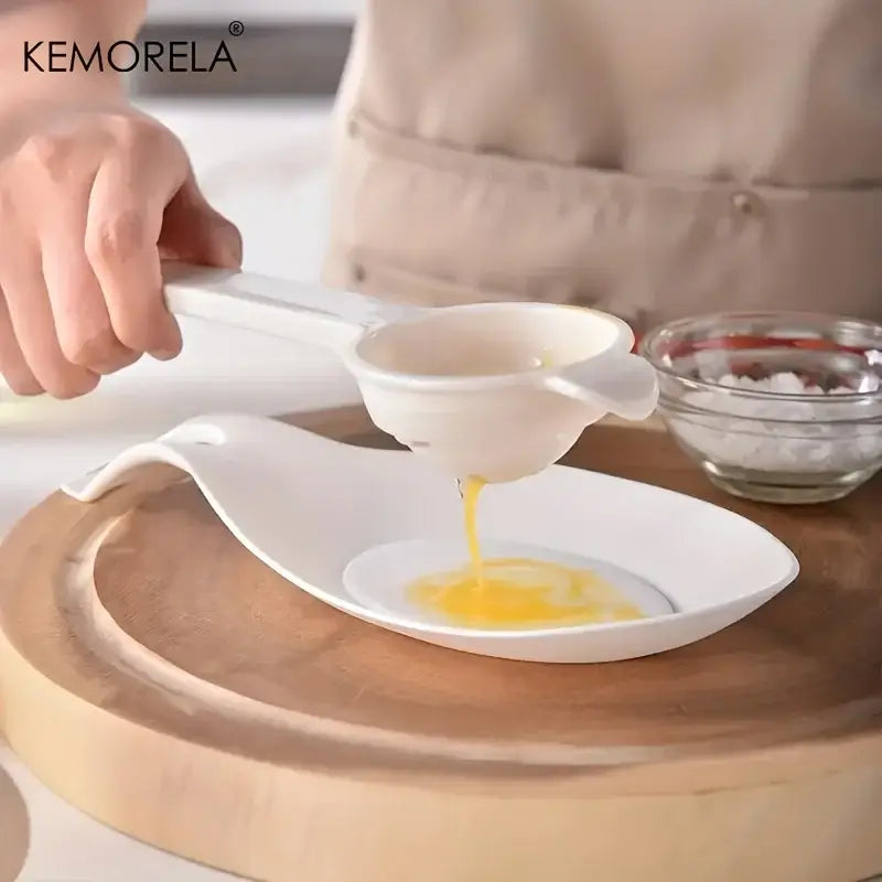 White ceramic egg yolk separator with handle and spout included in black and wood silicone kitchen utensil set