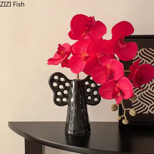 Black angel elephant ceramic vase with perforated wings holding vibrant artificial flowers for living room decorbites decor