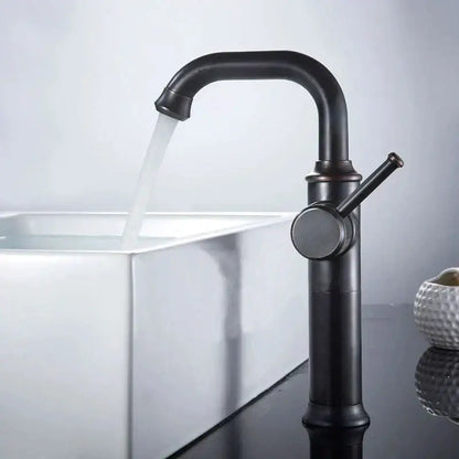 Black antique brass basin faucet in matte black with curved spout and single lever handle over white sink by decorbites