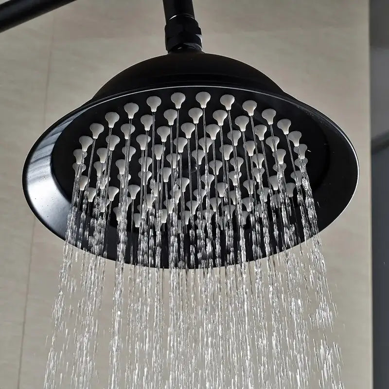 Black matte-finish shower faucet with multiple white nozzles spraying water in black bronze rainfall shower faucet set