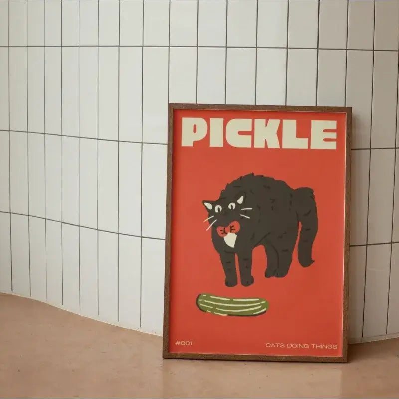 Framed DecorBites™ wall art canvas with a bold red background featuring a funny black cat holding a pickle