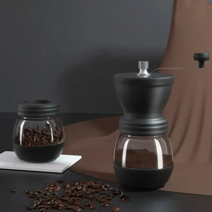 Black ceramic hand rocking coffee grinder with glass base and silver-toned handle for manual kitchen use