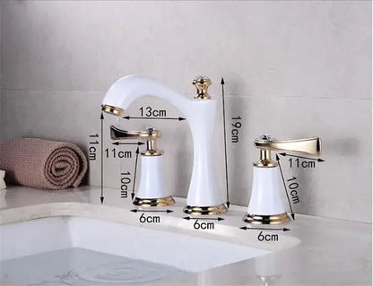 White ceramic bathroom sink faucets with gold brass accents and decorative crystal knobs for elegant bathroom use