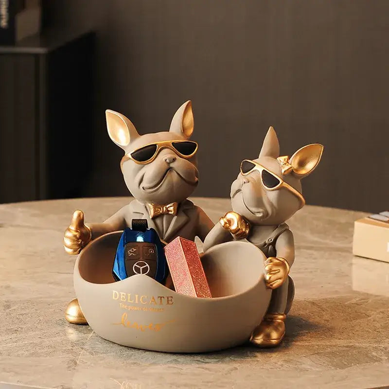 A beige and gold french bulldog butler statue office desk organizer featuring two dogs in sunglasses holding keys