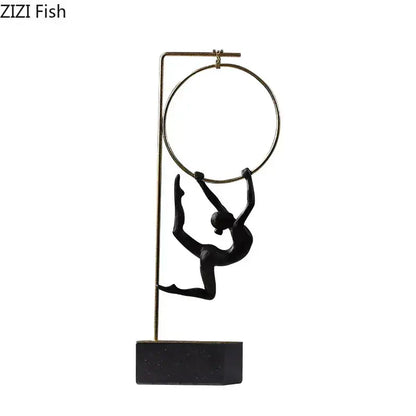 Black and gold gymnastic acrobat resin sculpture featuring a black figurine on gold-toned poles mounted on a sleek base