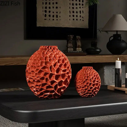 Two orange ceramic vases with honeycomb texture on a dark wooden table for artificial flower arrangement