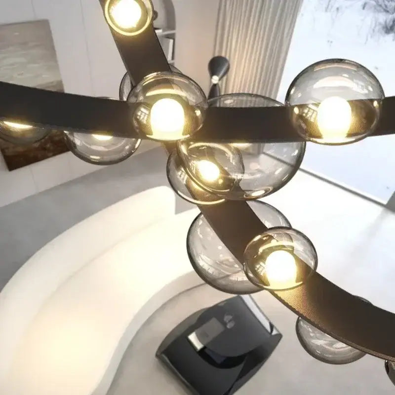 Black leather and glass pendant light with sleek black metal arms and glowing glass spheres as dining room focal point
