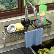 Black metal adjustable kitchen sink rack by decorbites with multiple compartments holding sponge scrubber and towel