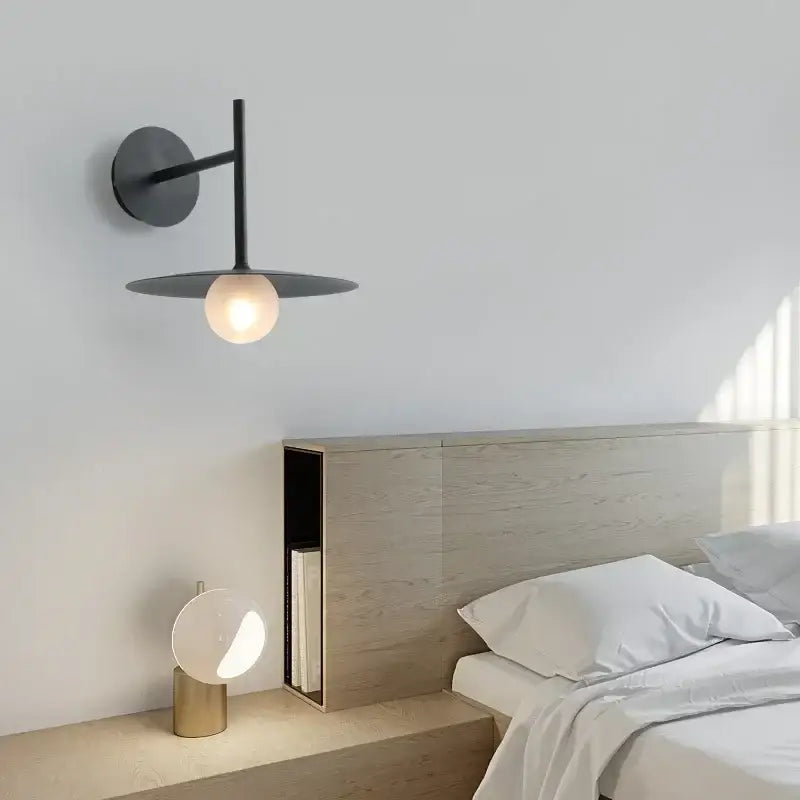 Black minimalist glass ball wall lamp with circular shade and warm glowing bulb for bedroom decorbites wall lamp