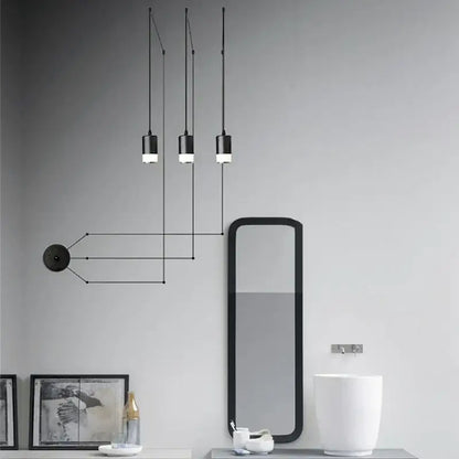 Three black minimalist led pendant lights hanging by cords emitting a soft glow for bedroom wall lamp decorbites