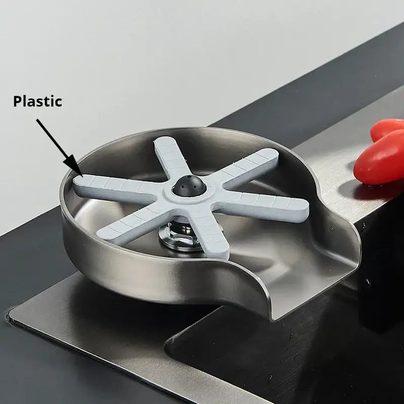 Black plastic glass rinser faucet towel ring with stainless steel sink drain cover and white star-shaped filter insert