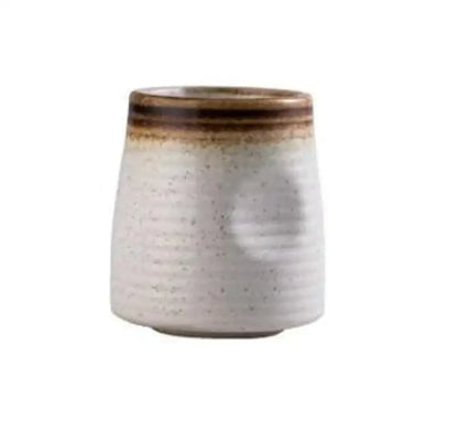 A rustic white ceramic wine sake tumbler with textured ribbed surface and brown glazed rim in a ceramic wine sake set